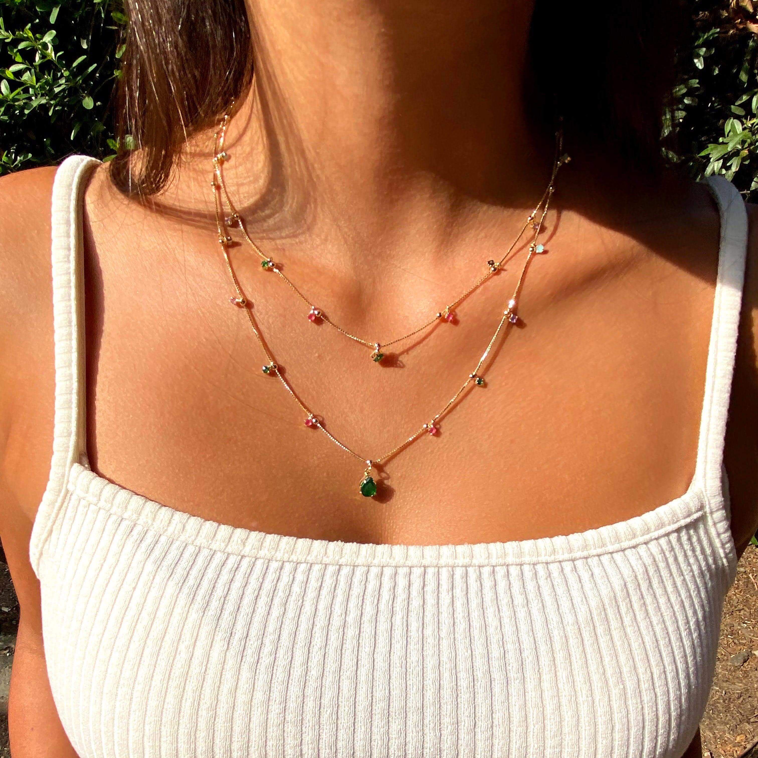 Layered 18k gold-filled necklaces at different lengths worn on the neck