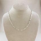Silver chain necklace on a mannequin bust against a neutral background