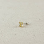 Gold and silver earring on a beige fabric background