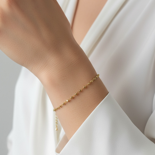 18K Gold Filled 2.5mm Beaded Bracelet – beaded Gold bracelet on a person's wrist with a white background