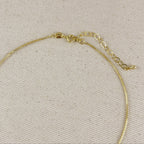Gold necklace on a beige fabric background